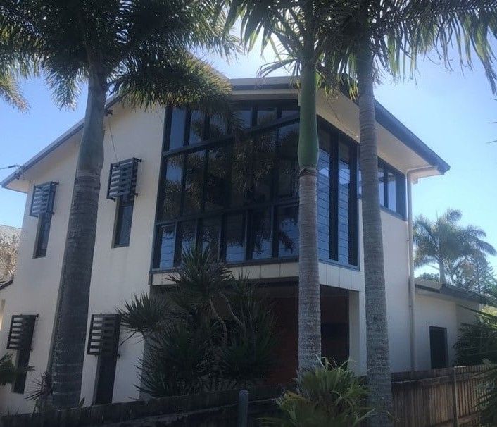 Two-story Beige House With Large Dark Windows, Palm Trees, and Blue Sky — Datco Windows & Doors Pty Ltd In South Murwillumbah, NSW
