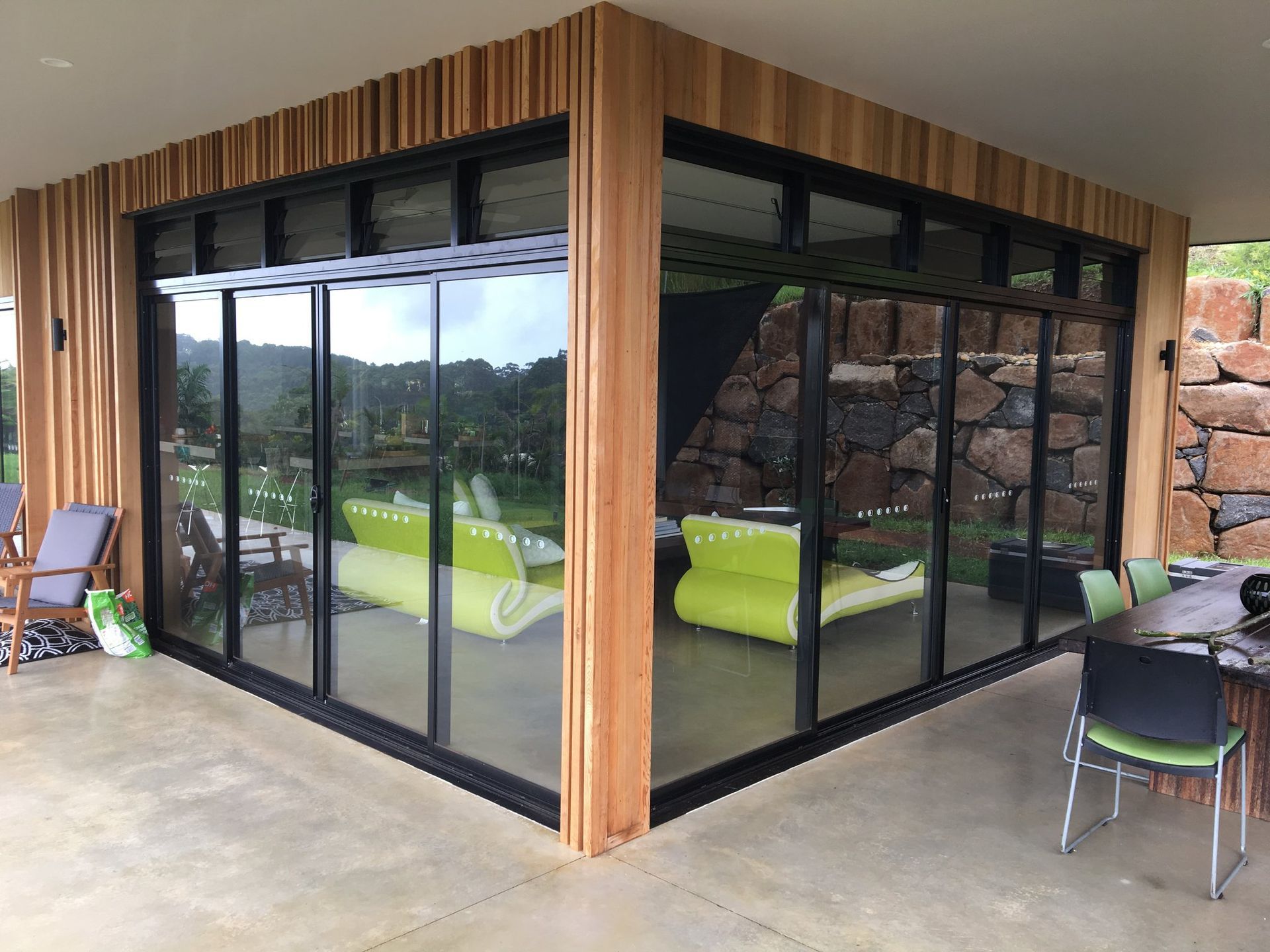 Corner of a Modern Building With Large Glass Windows and Wooden Accents — Datco Windows & Doors Pty Ltd In South Murwillumbah, NSW