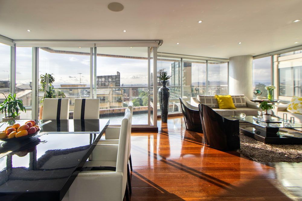 A Living Room With A Dining Table And Chairs And A Lot Of Windows — Datco Windows & Doors Pty Ltd In Casino, NSW