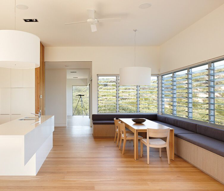 Modern Dining Room With a Table, Built-in Bench, and Large Window Overlooking Greenery — Datco Windows & Doors Pty Ltd In South Murwillumbah, NSW