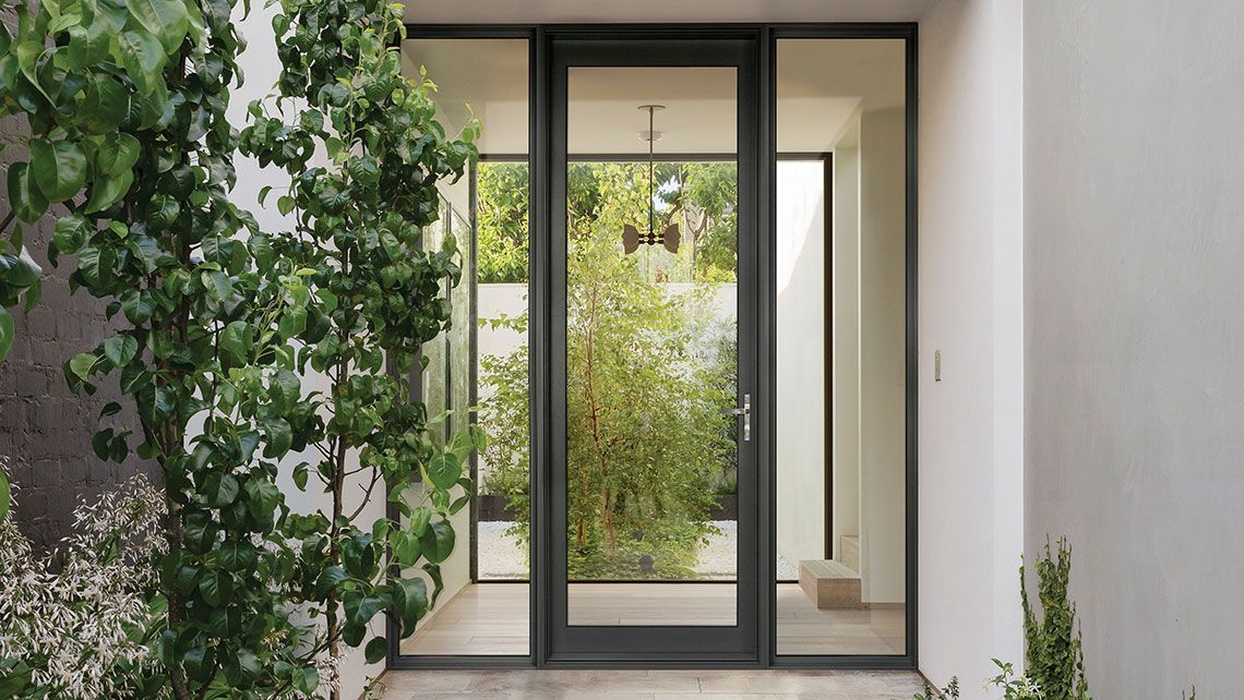 The Front Door Of A House And A Tree In The Background — Datco Windows & Doors Pty Ltd In Casino, NSW