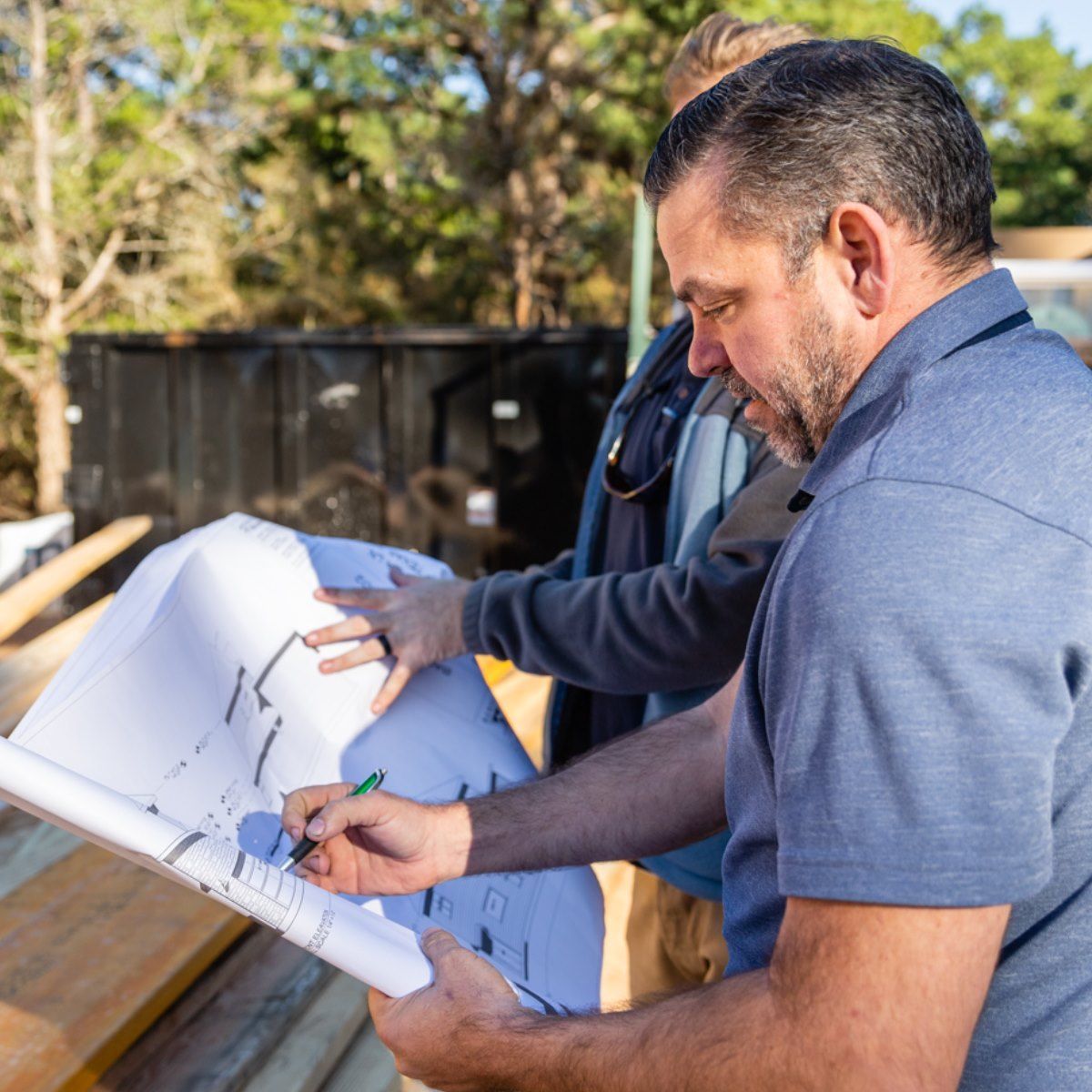 Two men are looking at a blueprint together.