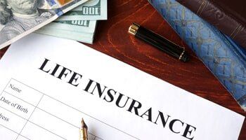 Insurance Agency — Life Insurance Policy and Currency on Table in Orlando, FL