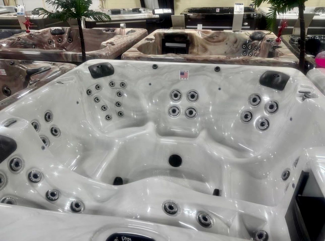 White multi-seat hot tub with jets in a showroom display