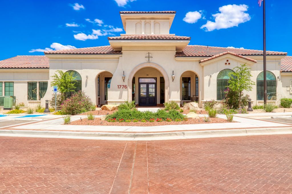 A large white building with a tiled roof and a flag in front of it.