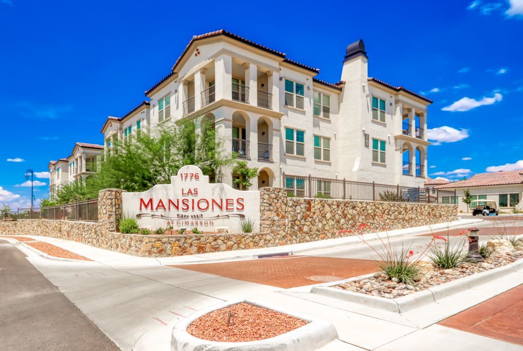 A large white building with a sign in front of it that says las mansiones.