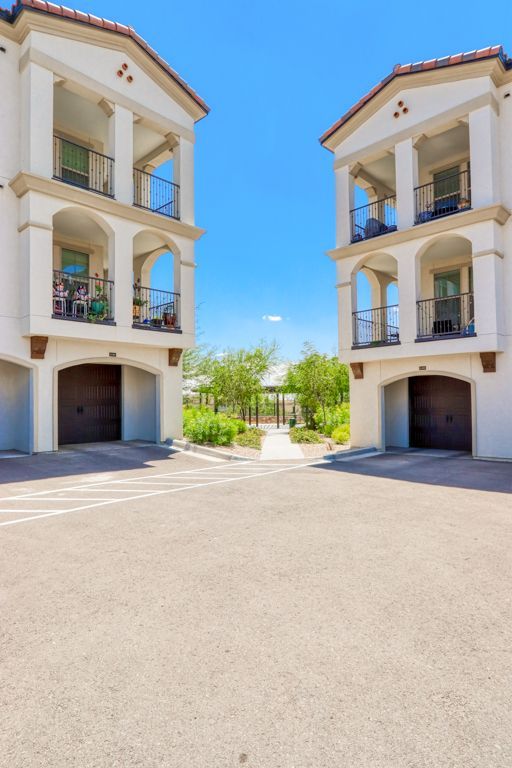 A white apartment building with balconies and garages