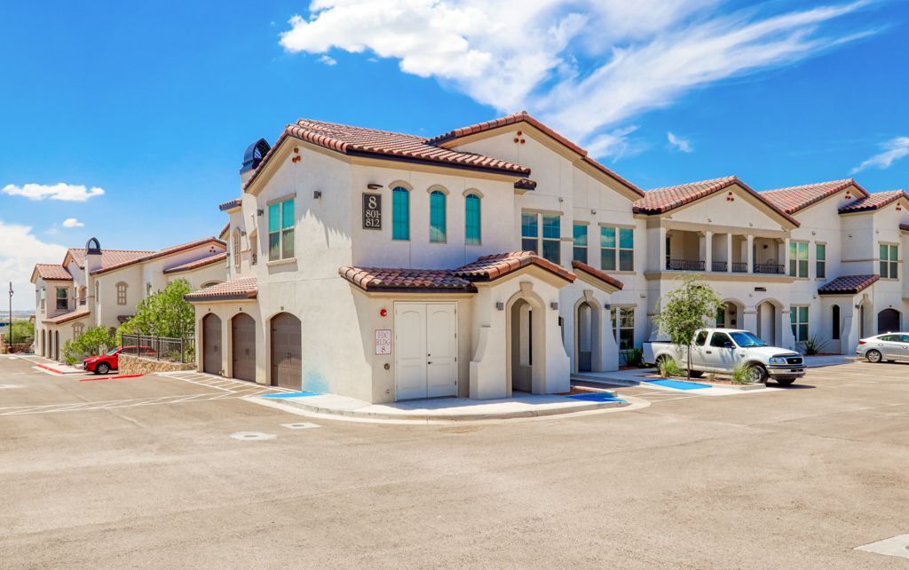 A large white building with a parking lot in front of it