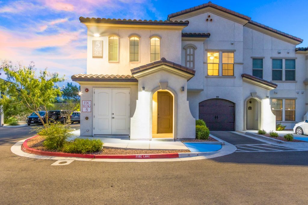 A large white house with a car parked in front of it.