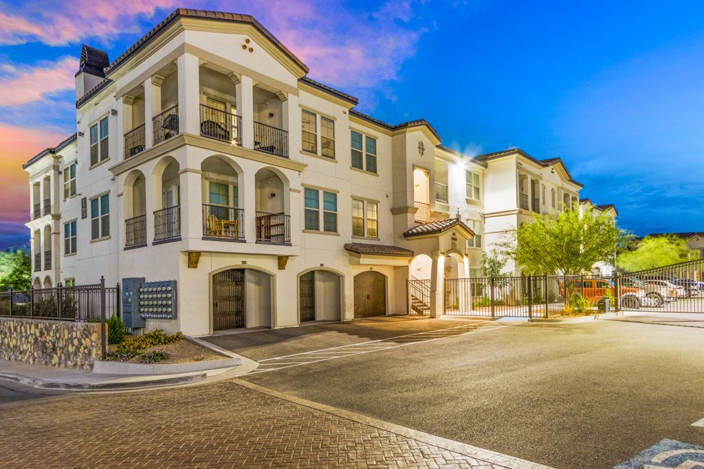 A large white building is sitting on the corner of a street.