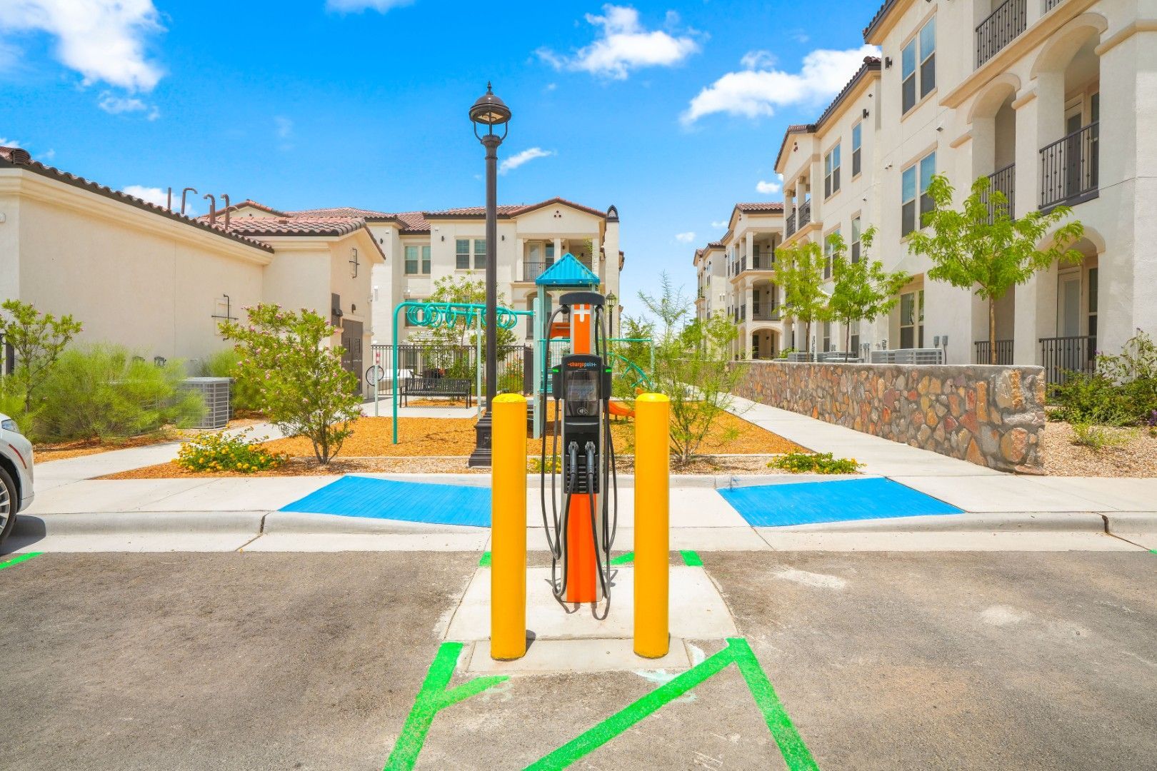 A car is being charged at a charging station in a parking lot.
