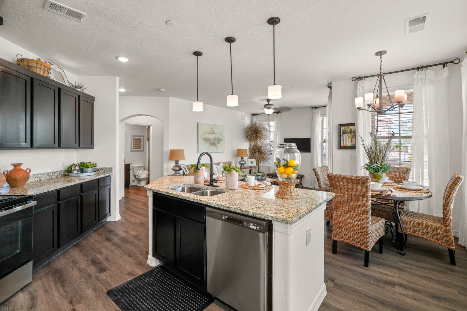 A kitchen with stainless steel appliances and granite counter tops in a model home.