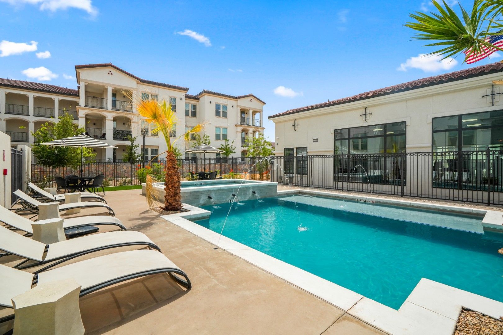 There is a large swimming pool in front of a building.