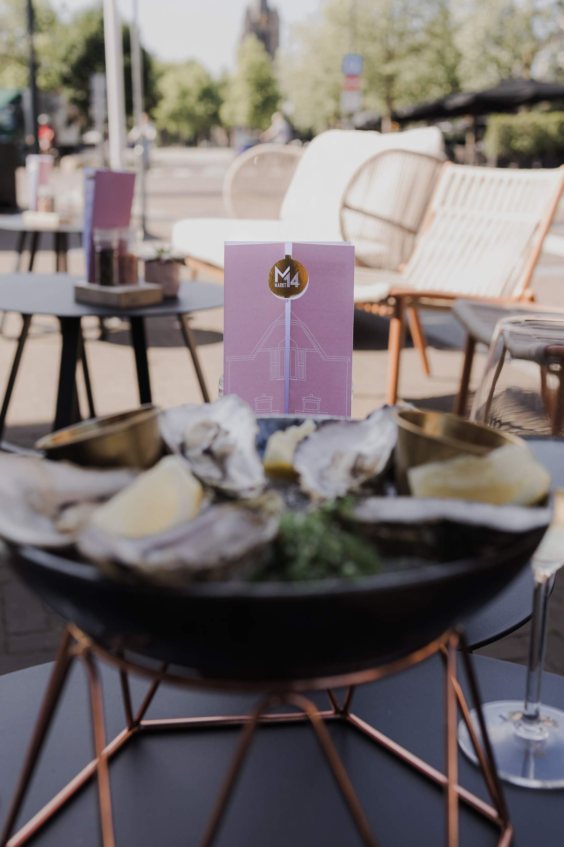 Een barman schenkt met een glimlach een cocktail uit een shaker in een martiniglas.