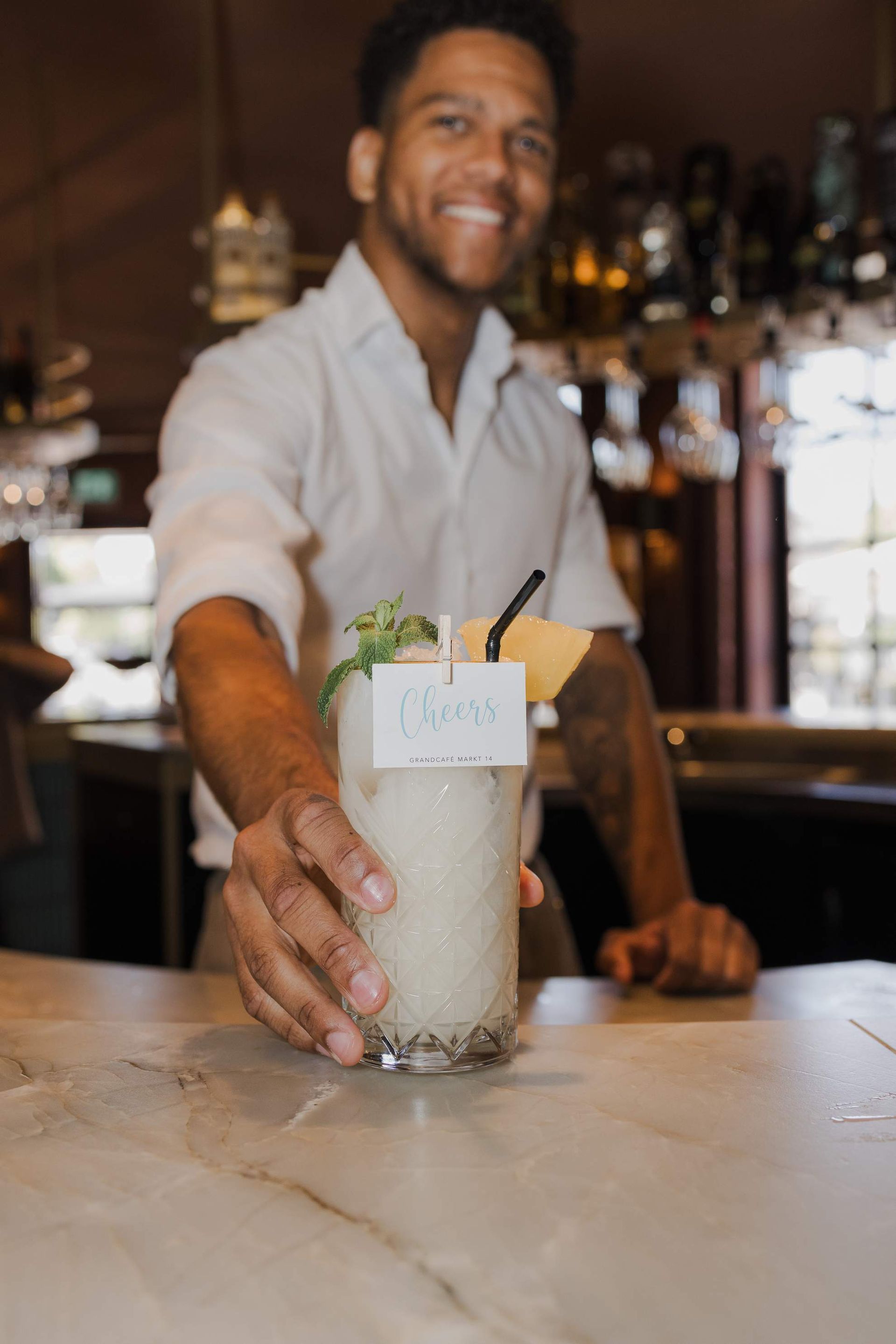 Een barman schenkt bier uit de tap in een hoog glas, in een restaurant.