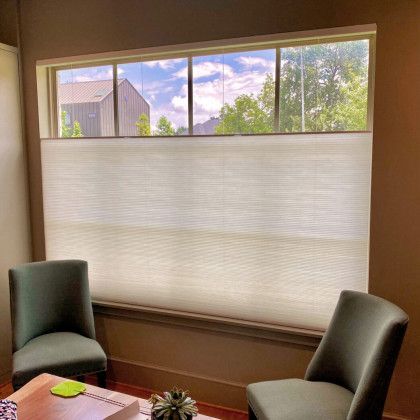 A living room with two chairs and a coffee table in front of a large window