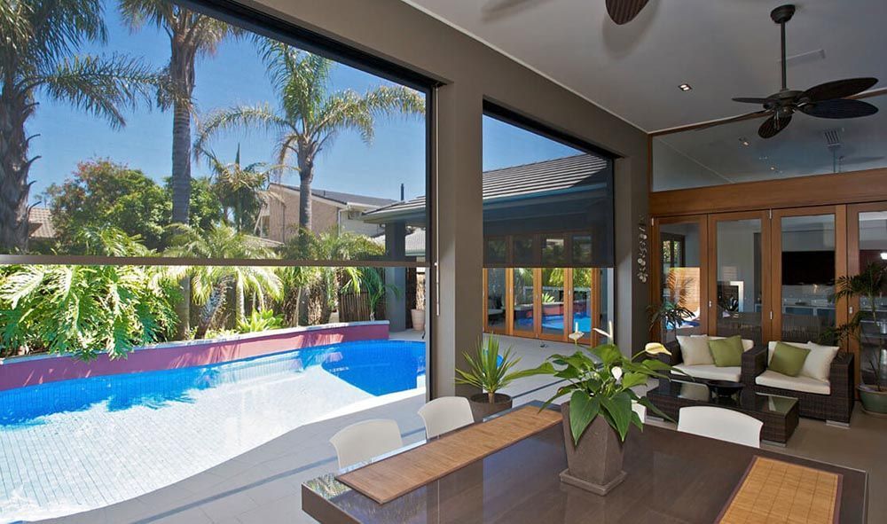 A dining room table with a view of a swimming pool