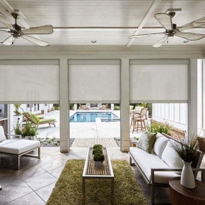 A living room with a couch, table, chairs and ceiling fans
