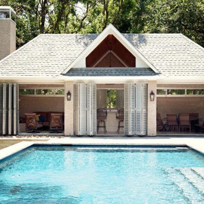 A large house with a swimming pool in front of it