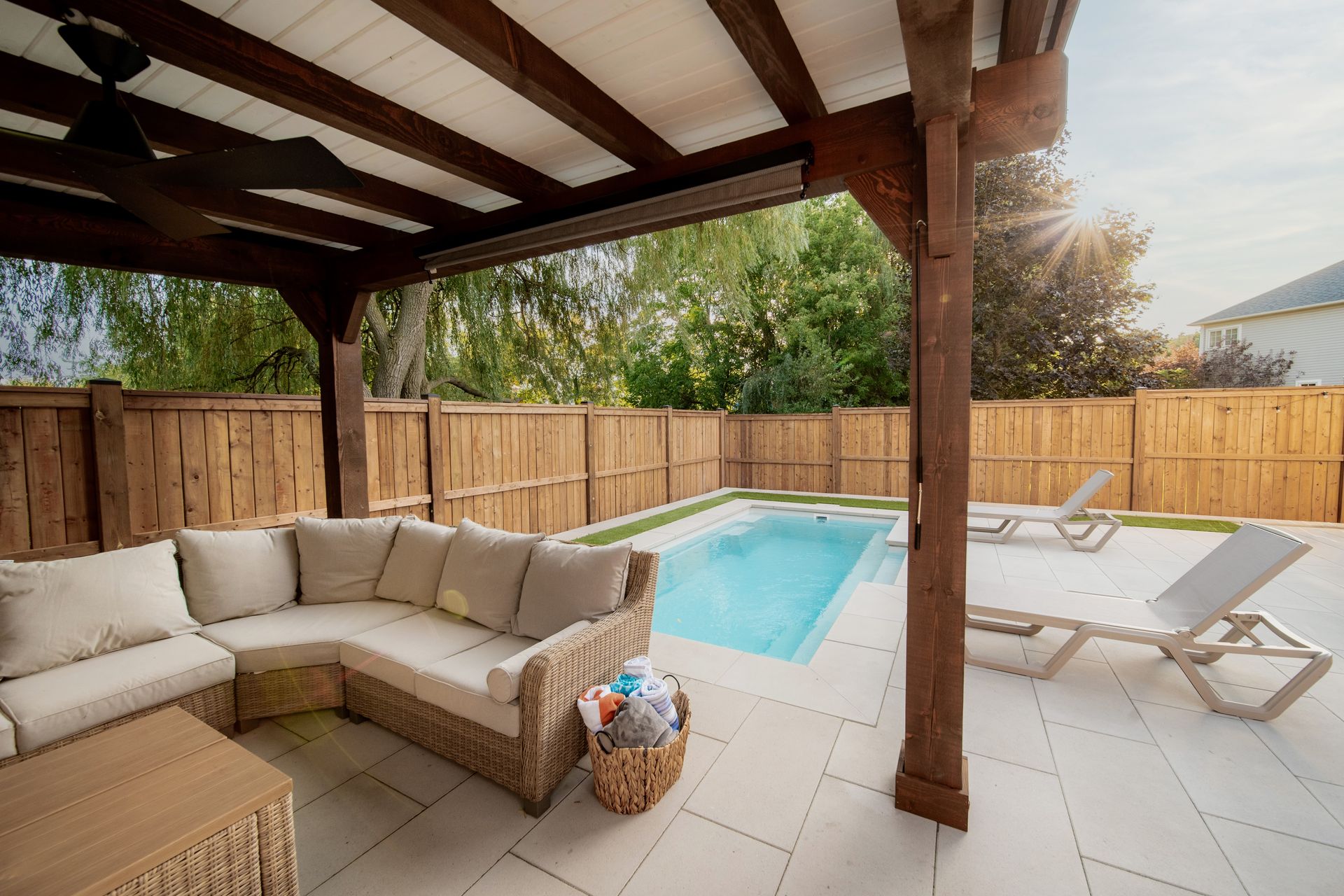 Backyard transformation with a Latham Tuscan 11×20 fiberglass pool, stone patio, and greenery.