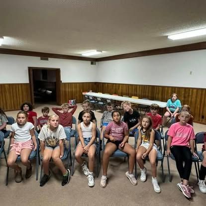 A group of children are sitting in chairs in a room.