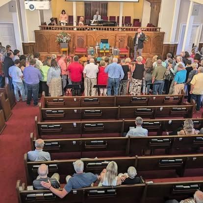 A large group of people are sitting in a church.