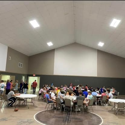 A large group of people are sitting at tables in a large room.