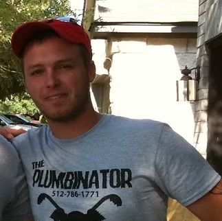 A person wearing a red baseball cap and a grey 