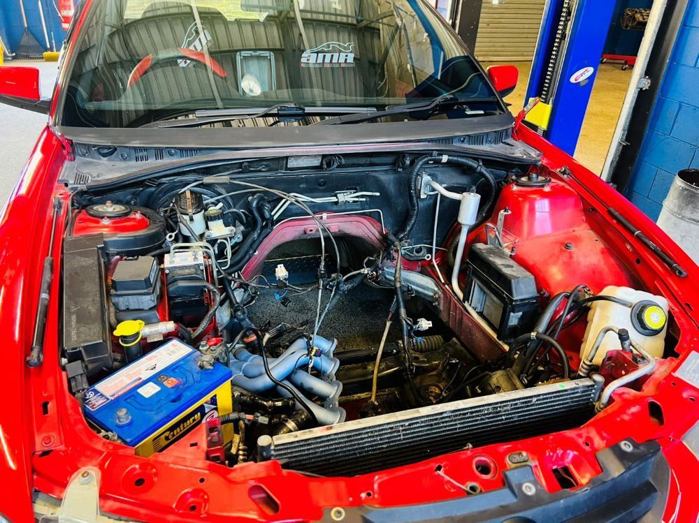 Red Car Engine Bay Being Worked on in a Garage — Wellers Automotive & Performance in Urangan, QLD