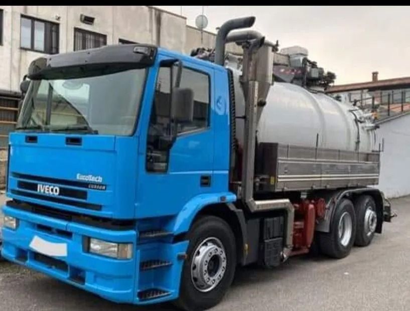 Autospurgo Iveco Eurotech blu, parcheggiato. Serbatoio grigio, tubi di scarico neri, vista frontale.