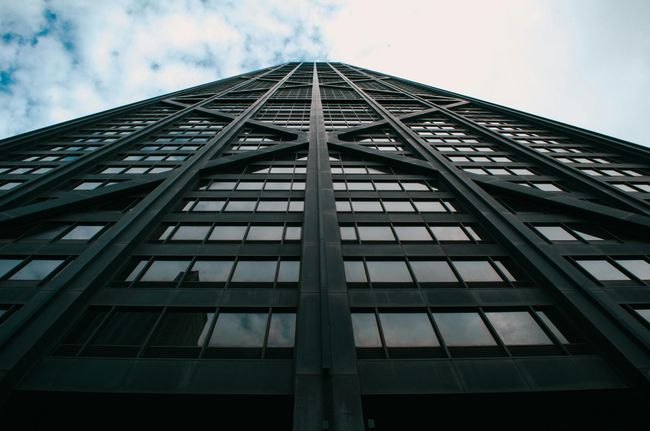 Looking up at a tall building with a blue sky in the background.