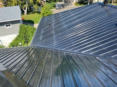 A black metal roof is sitting on top of a house.
