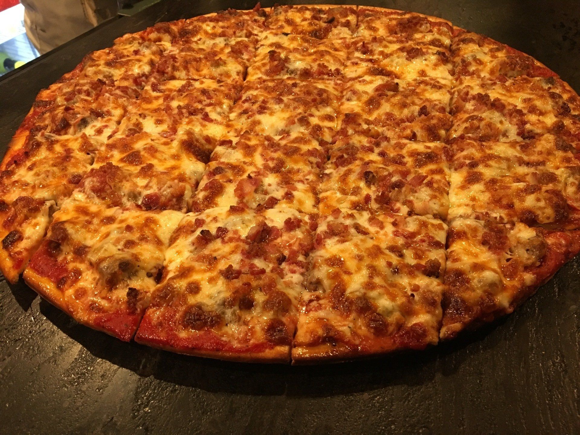 A pizza with a lot of cheese on it is sitting on a table.
