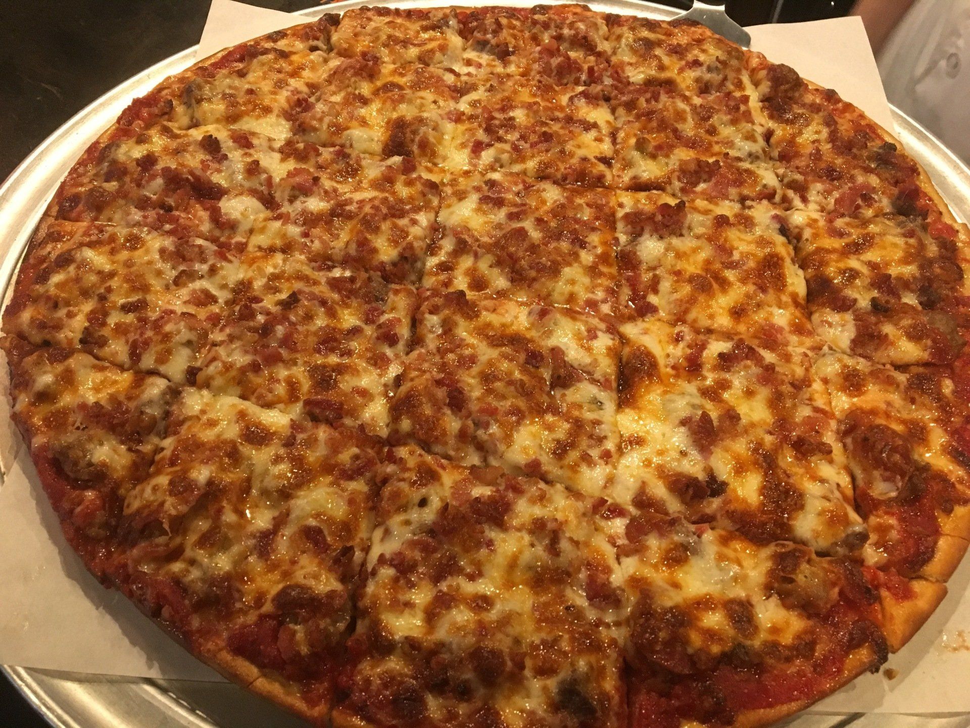 A pizza with a lot of cheese on it is on a pan.