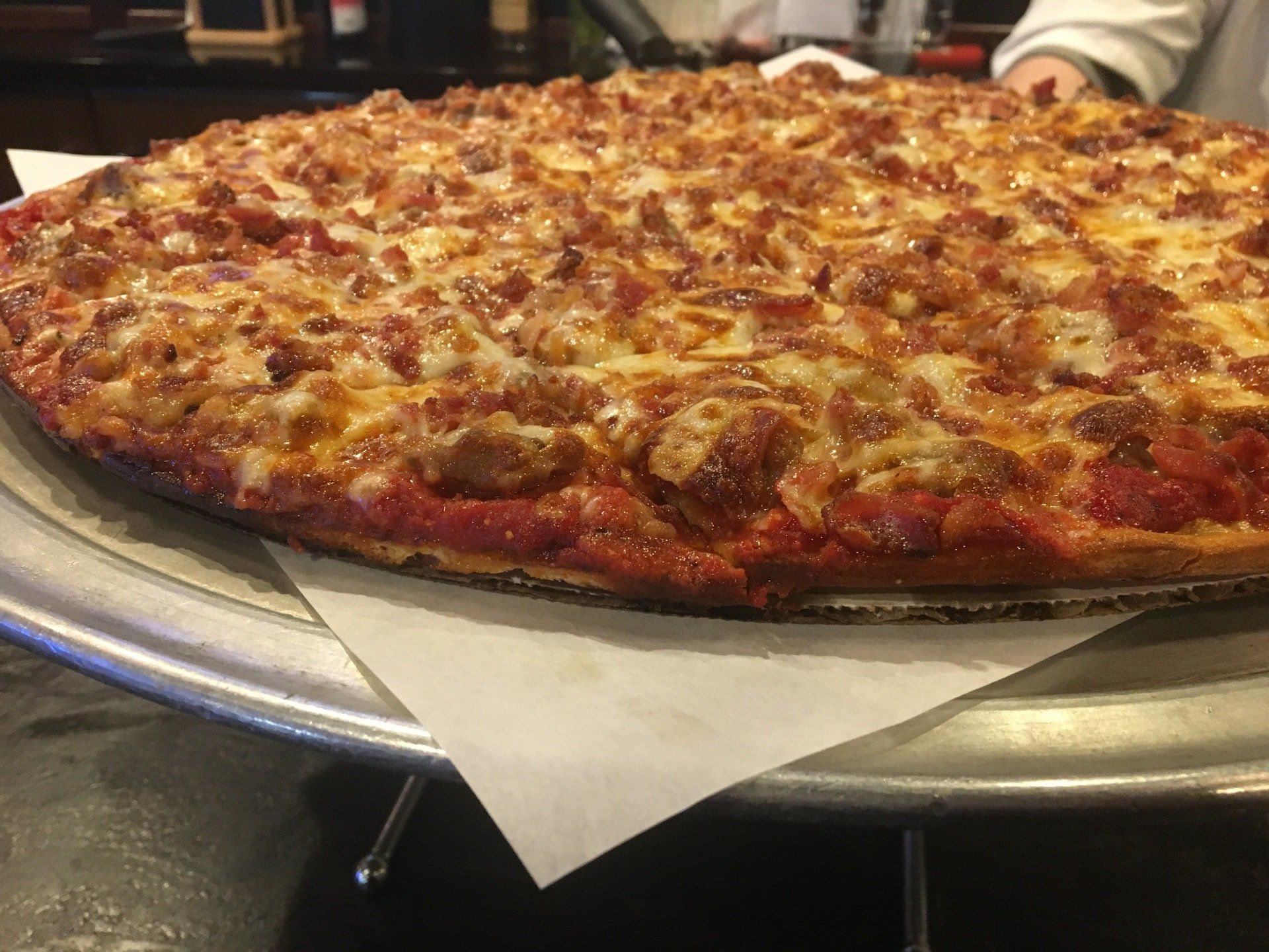 A pizza with tomato sauce and cheese is on a pan.