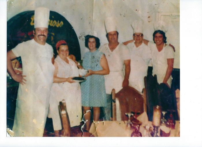 A group of people wearing chef hats are posing for a picture