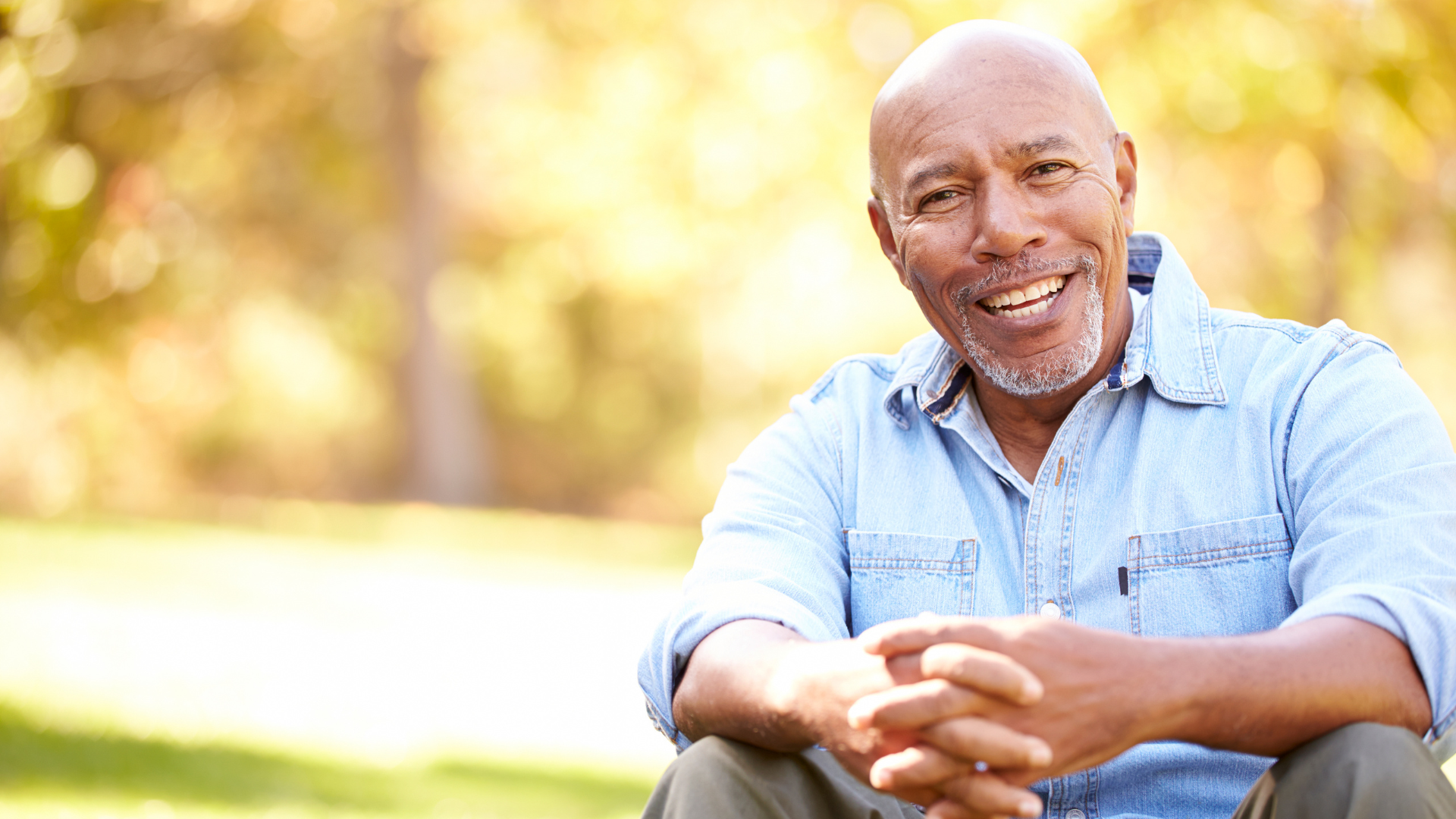 A man and a woman are sitting on a couch looking at a laptop.