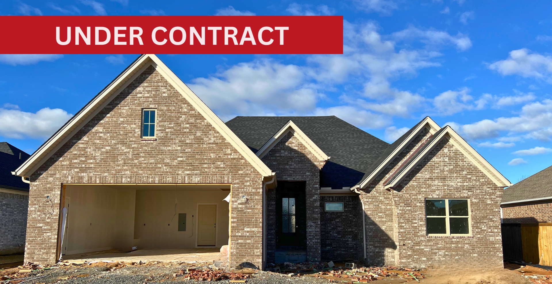 Simple custom home built by hines homes with dark brick and a white accent wall out front with a curved front porch