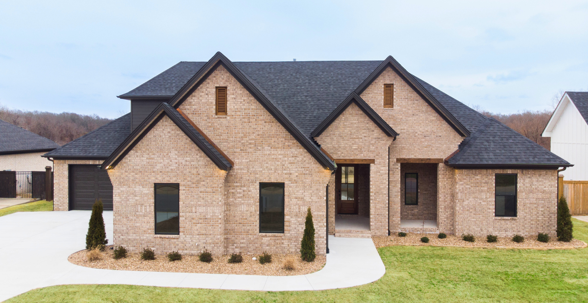 modern new construction home with white and great exterior and unique porch with a curve at the top by hines homes