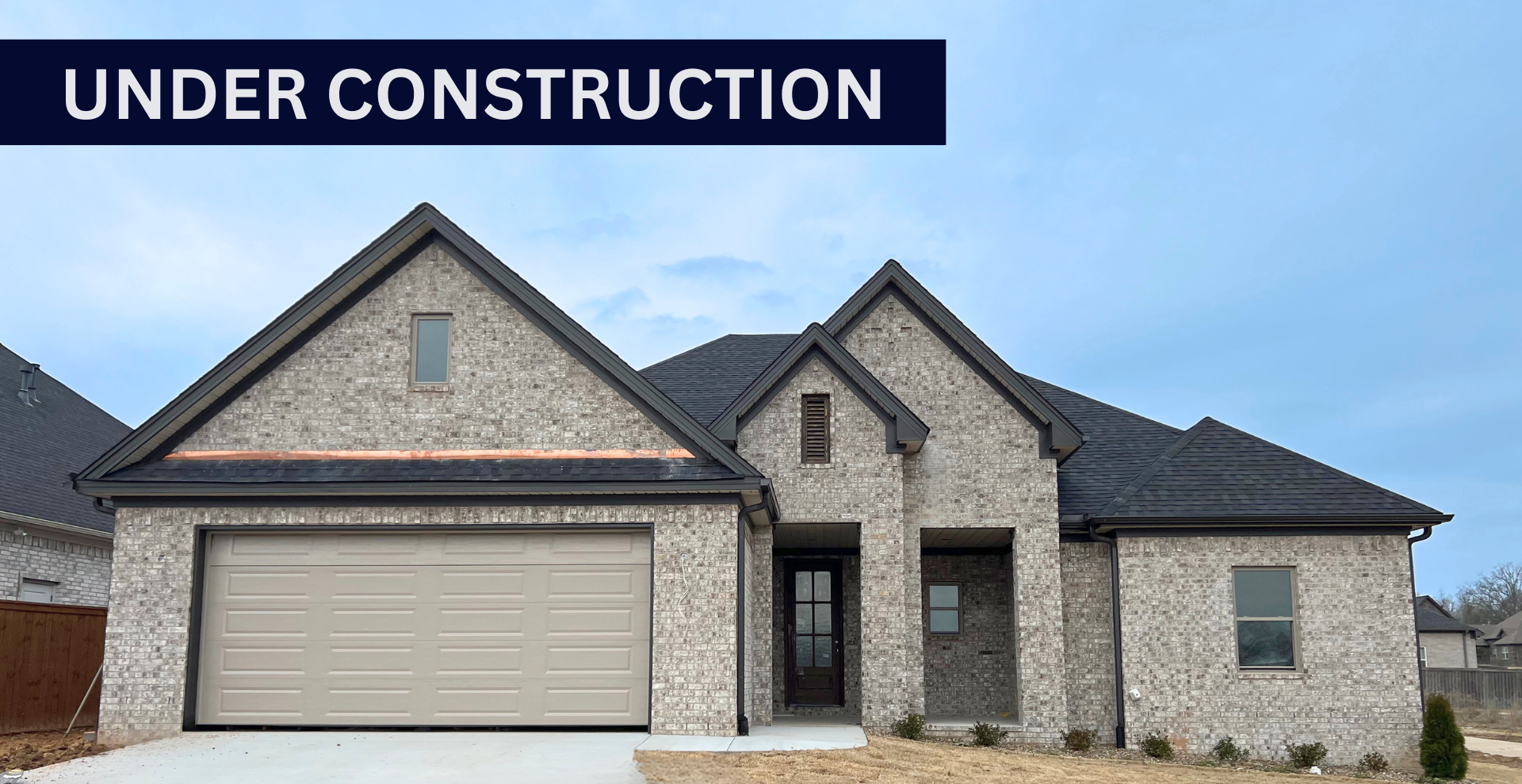 Simple custom home built by hines homes with dark brick and a white accent wall out front with a curved front porch