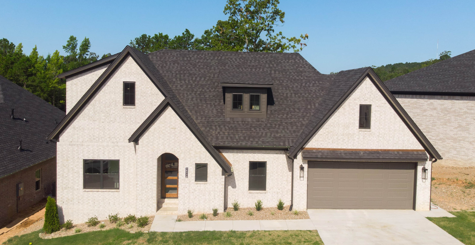 new construction home that is two story and lighter exterior colors. full of windows for natural light