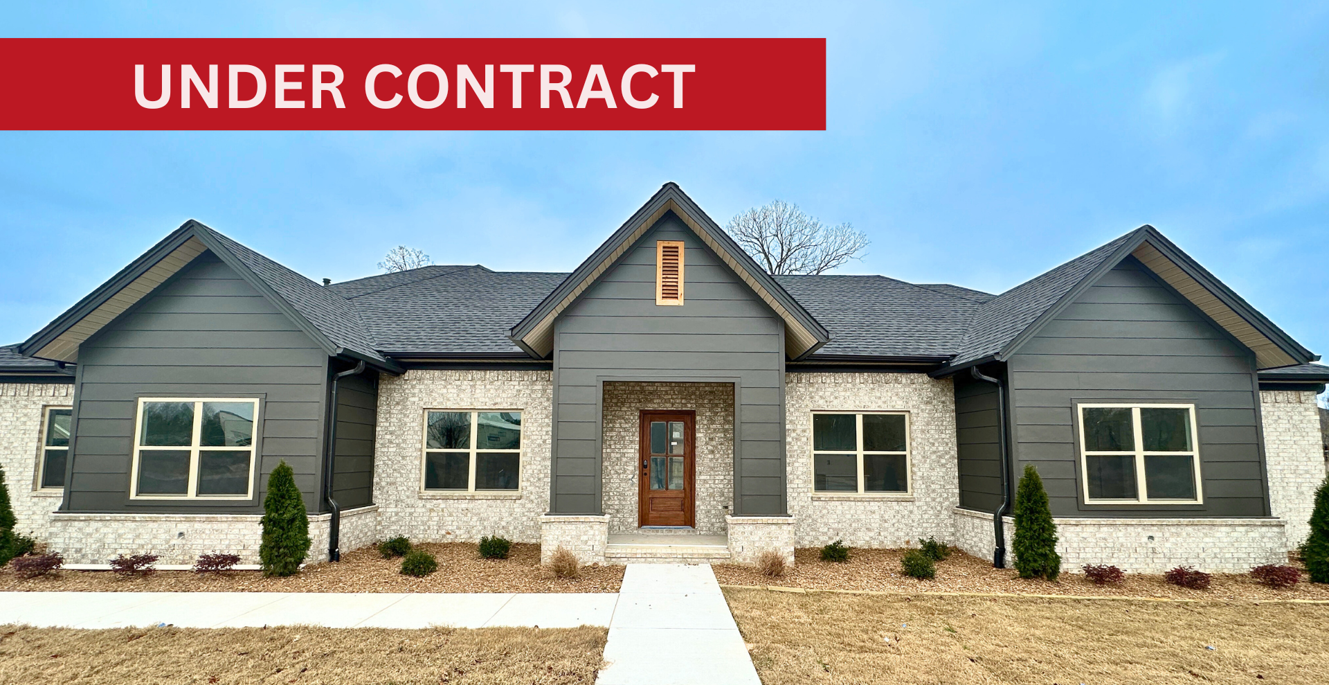 modern new construction home with white brick exterior and dark roof  built by hines homes