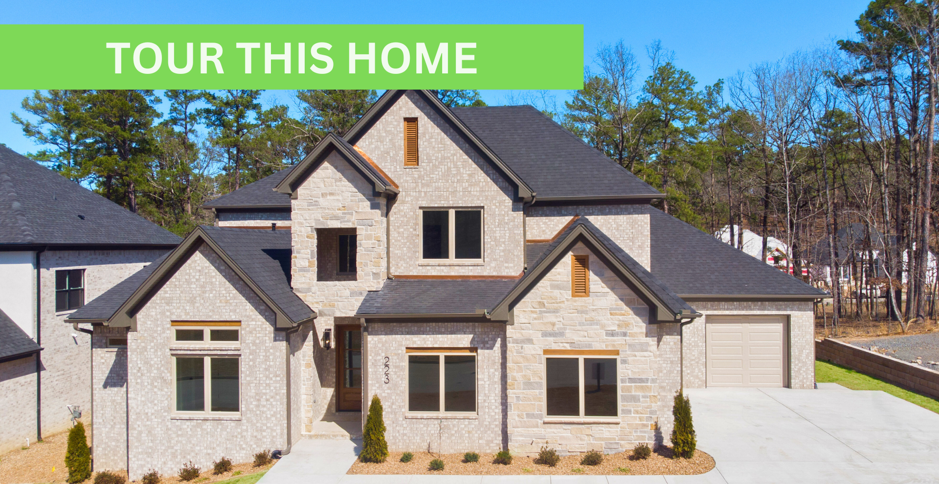 new construction home with beige exterior with lots of windows and two stories by hines homes
