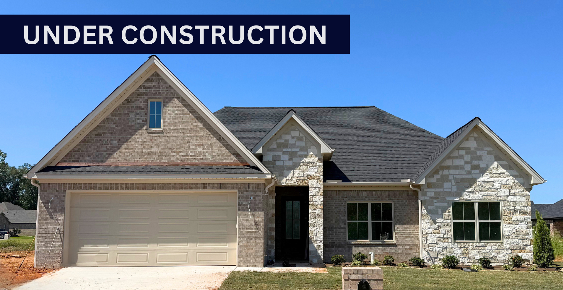 Simple custom home built by hines homes with dark brick and a white accent wall out front with a curved front porch