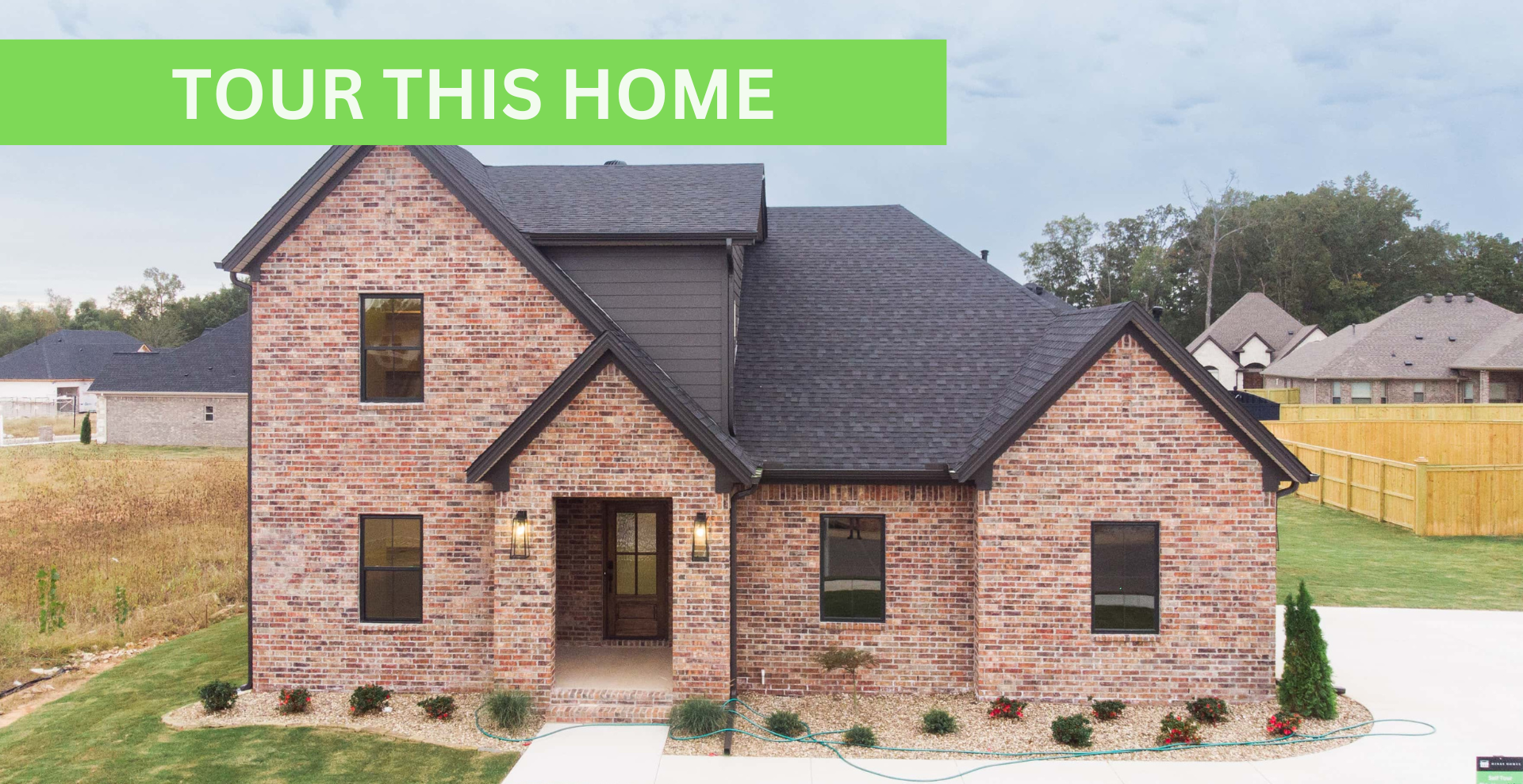 Simple custom home built by hines homes with dark brick and a white accent wall out front with a curved front porch
