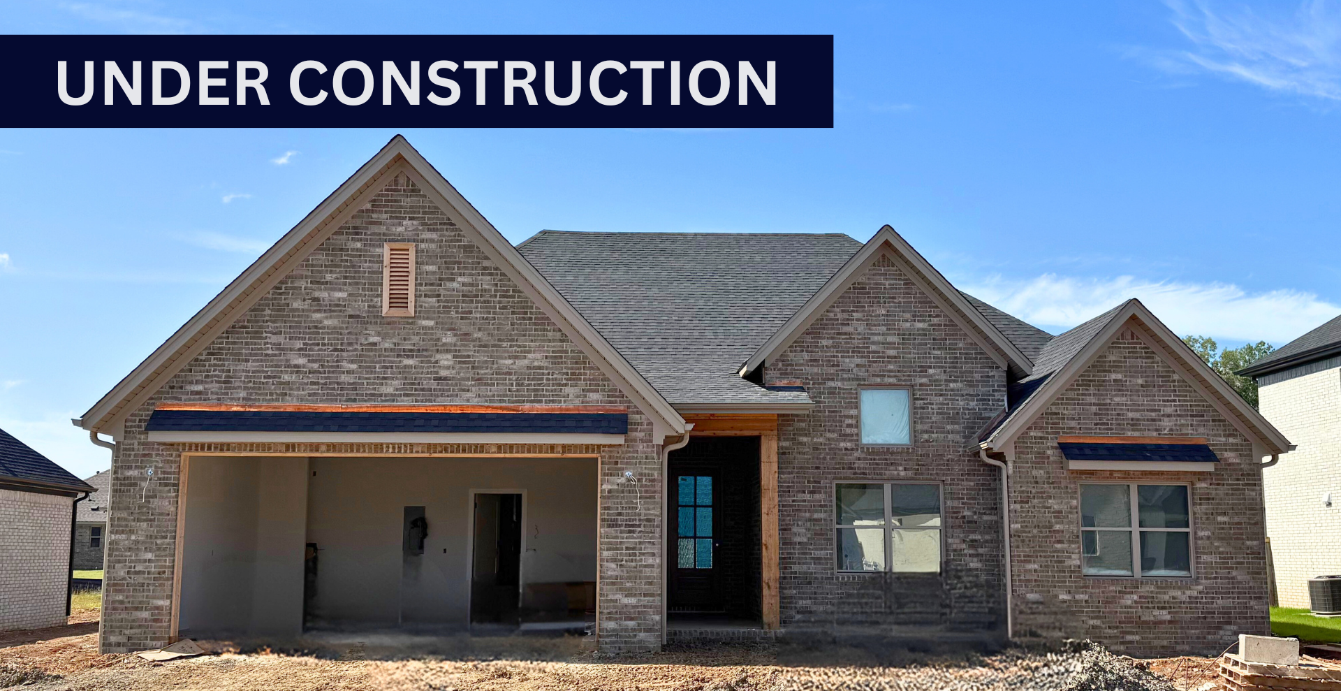 Simple custom home built by hines homes with dark brick and a white accent wall out front with a curved front porch
