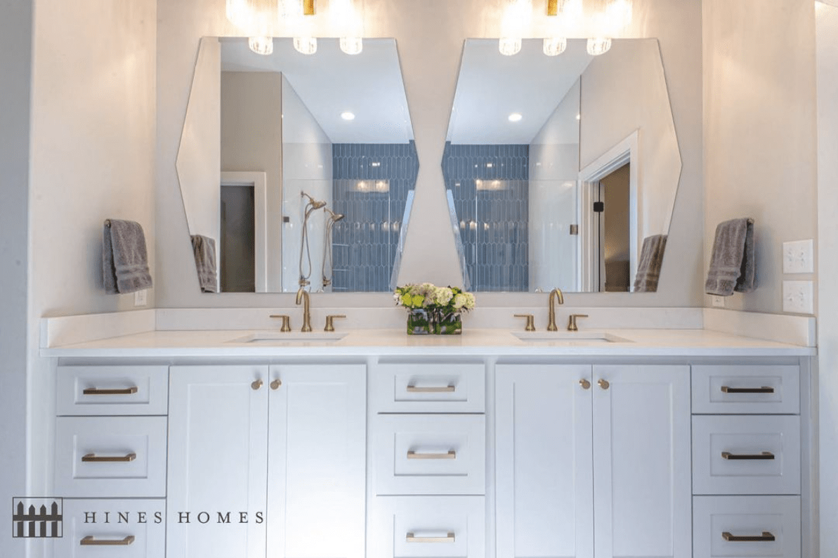 master bathroom with white cabinets and big mirrors to view the natural light built by hines homes