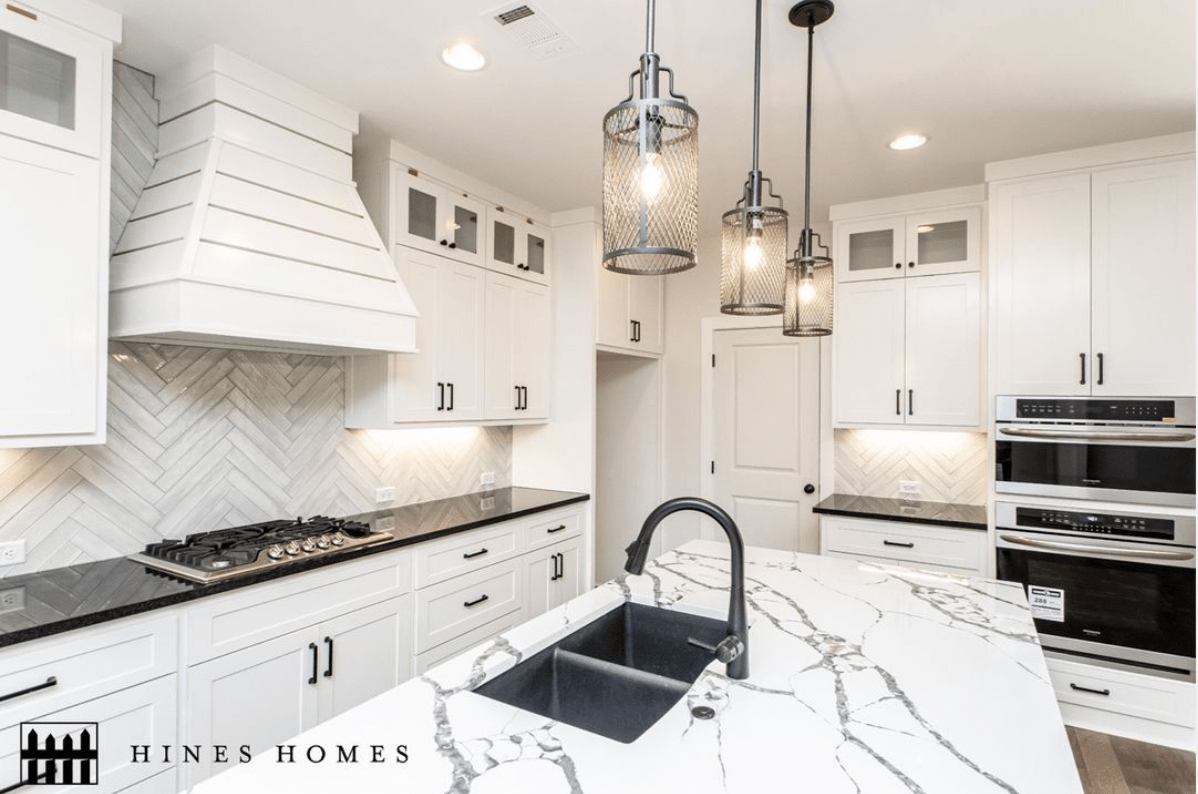 Kitchen with open floor plan and white countertops to match the white cabinets built by hines homes