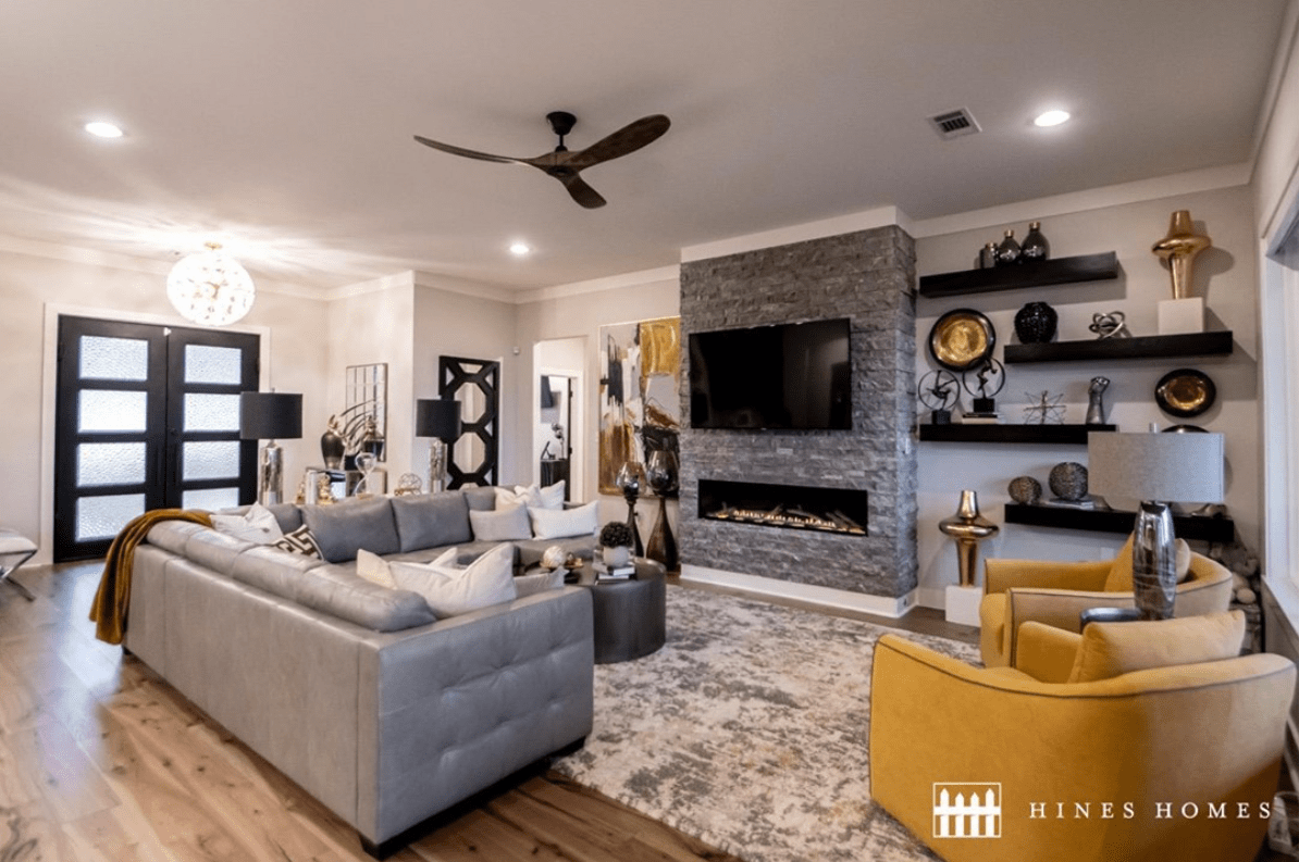 cozy living room with leather seating and a big dark fireplace to hang tv built by hines homes