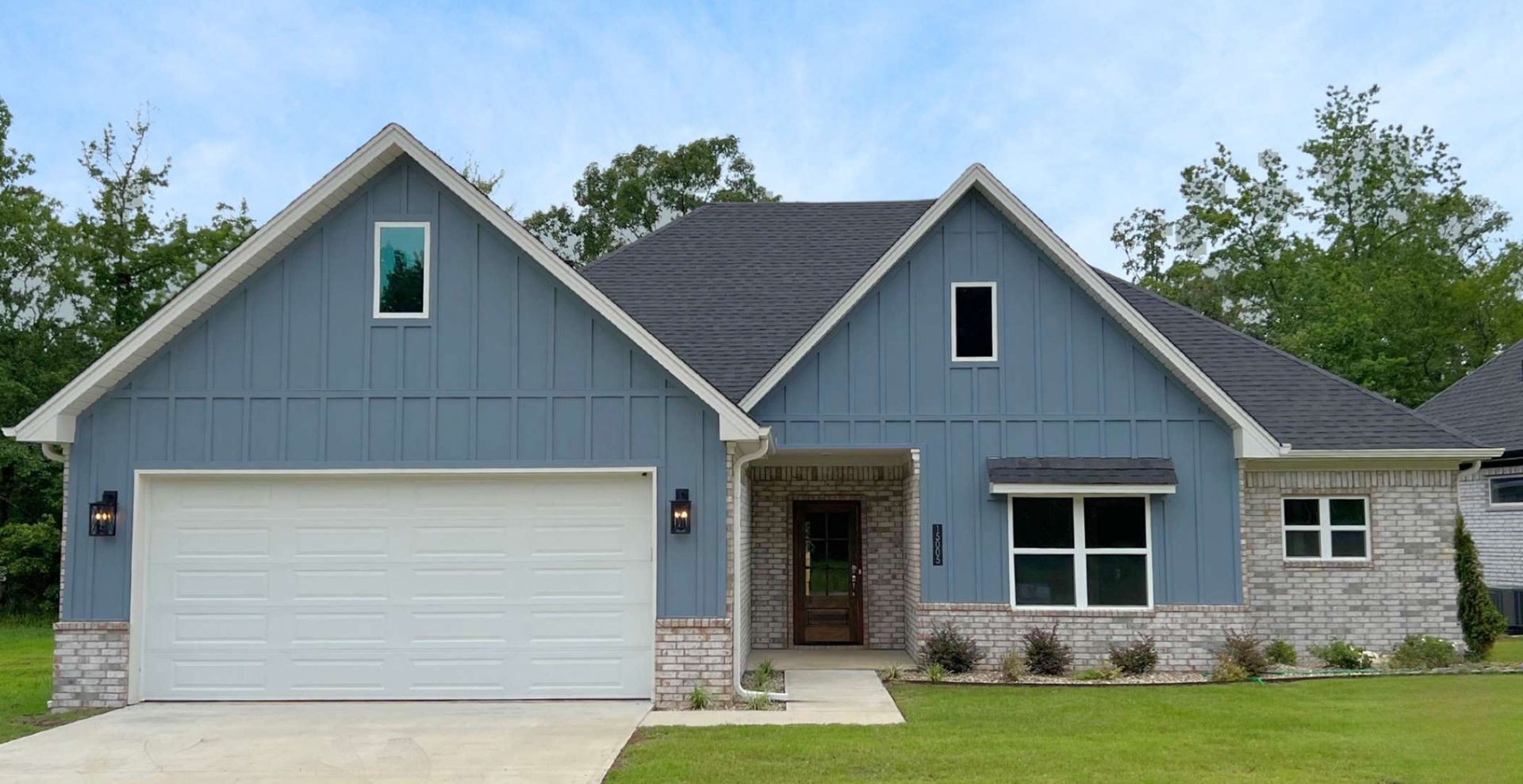 brand new construction home with brown garage door and beige brick
